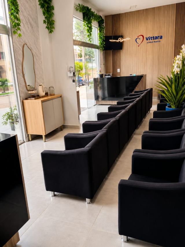 Recepção da Vittara Clínica Médica, com poltronas e o logo na parede